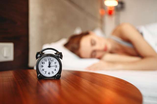 What Is The Best Wake Up Routine – peaceful early morning sleep with alarm clock.