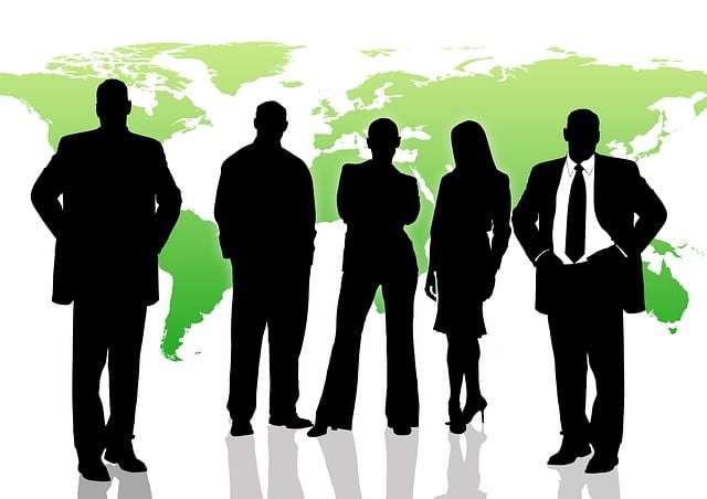 Silhouettes of professionals standing in front of a world map, representing social awareness and leadership intelligence.