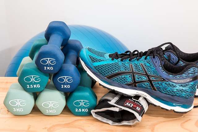 Dumbbells and running shoes set up for moderate exercise to maintain balanced immune system health