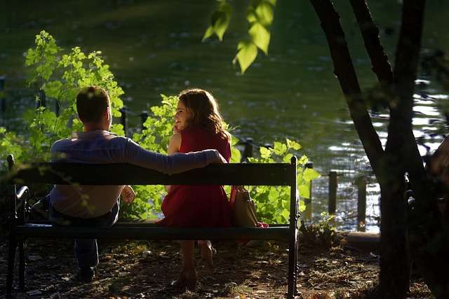 Couple relaxing on a park bench by a lake to reduce stress and calm an overactive immune system